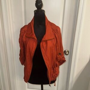 This rust-colored lightweight jacket in size large features roll-up sleeves.